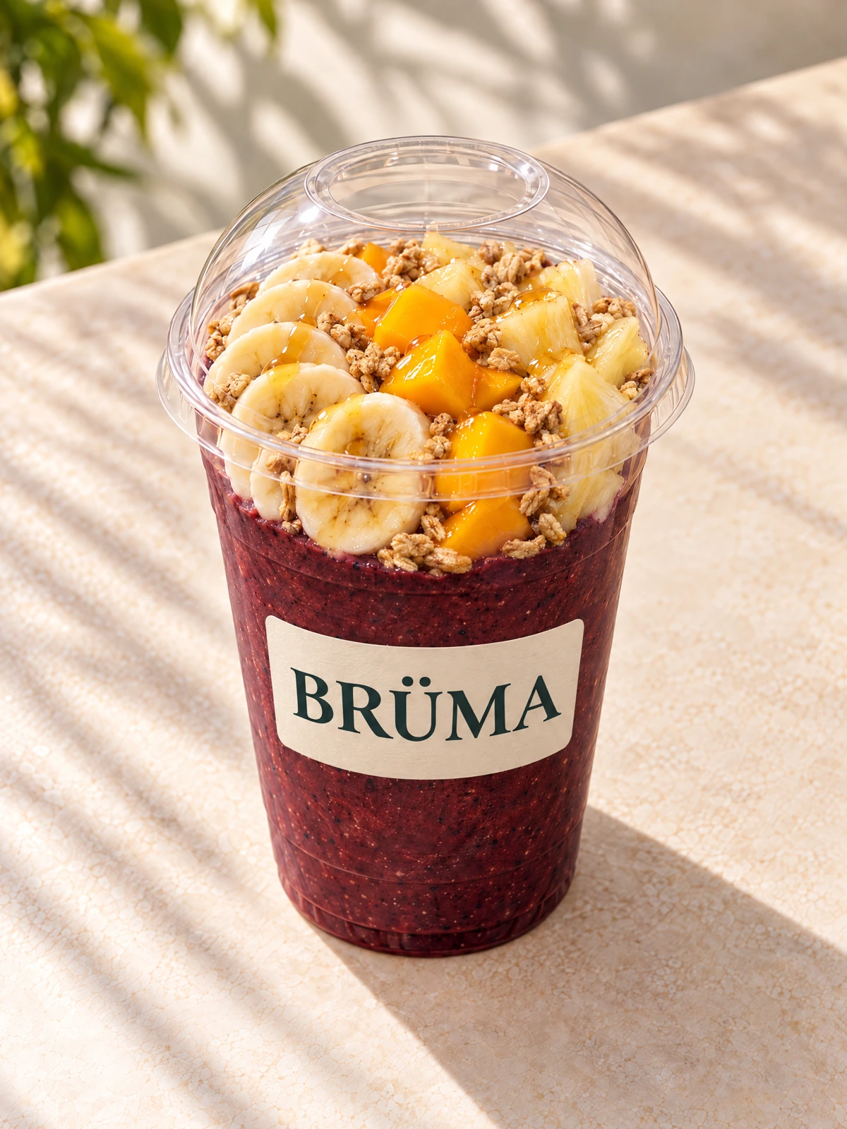 Tropical açaí with mango, pineapple, banana, granola and honey in a BRÜMA cup